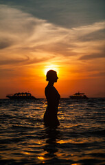 woman silhouette in the sea at sunset