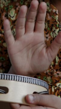 Close up of hand hitting a tambourine 