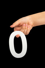 Zero in hand. The number zero is clasped in a hand isolated on a black background. Number zero...