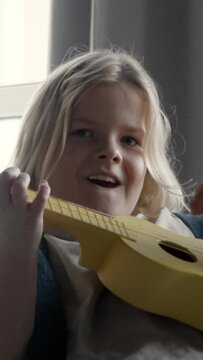 a group of children playing music together in a band, close up on the guitarist  