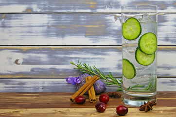 Closeup of isolated gon tonic cocktail glass, cucumber slices, botanicals cinnamon, lavender,...