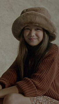 Young asian girl standing in front of a backdrop in photography studio looking confident