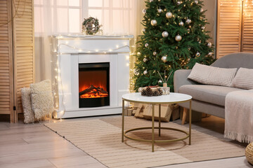 Naklejka premium Interior of living room with fireplace, glowing lights and Christmas tree