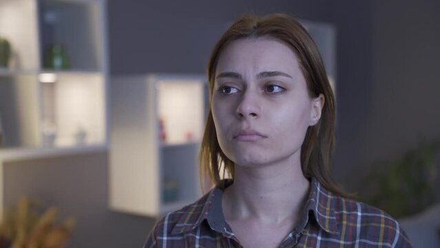 Cry. The woman is unhappy and crying inside the house.
The woman at home is not feeling well and is crying.
