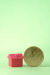 Casa junto a dinero, montaña de monedas de euro, inflación y subida de Euribor