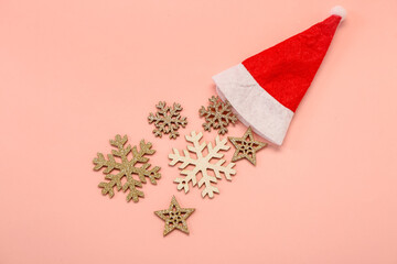 Composition with Santa hat and Christmas decorations on pink background