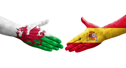 Handshake between Spain and Wales flags painted on hands, isolated transparent image.