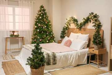 Interior of bedroom with glowing Christmas trees and fir branches