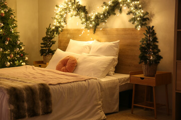 Interior of bedroom with glowing Christmas trees and fir branches