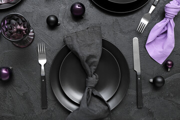 Beautiful table setting with Christmas balls on black background, top view