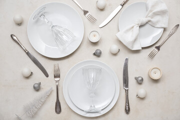 Beautiful table setting with Christmas balls and candles on white background