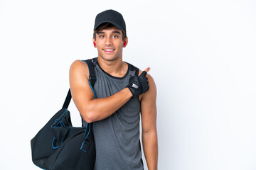 Young sport caucasian man with sport bag isolated on white background pointing to the side to present a product