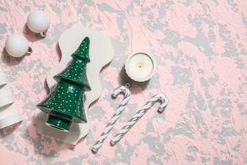 Decorative Christmas tree with podiums, candle, candy canes and balls on grunge background
