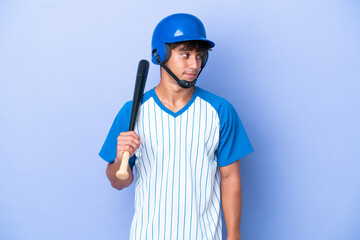 Baseball caucasian man player with helmet and bat isolated on blue background looking to the side
