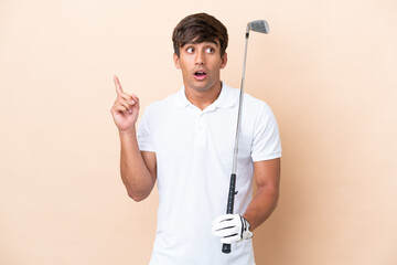Young golfer player man isolated on ocher background thinking an idea pointing the finger up
