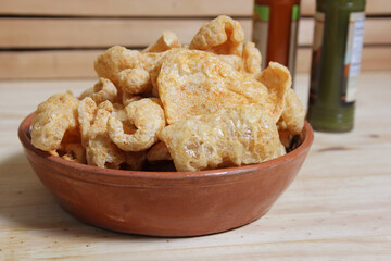 Fried Pork Skins With Hot Sauce in Rustic Kitchen