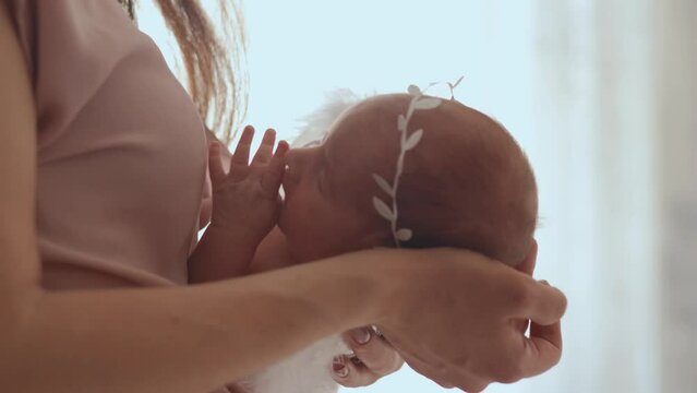 mom cradling her newborn baby angel. close-up.