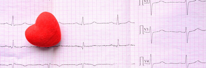 Panoramic view on red heart on sheet of pink millimeter paper with diagram of medical examination...