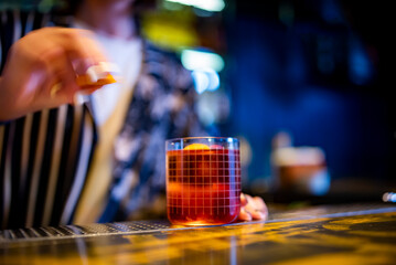 woman hand bartender making negroni cocktail in bar
