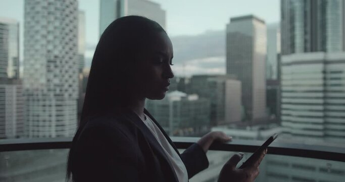 Woman Looking at Smart Phone and City Skyline View