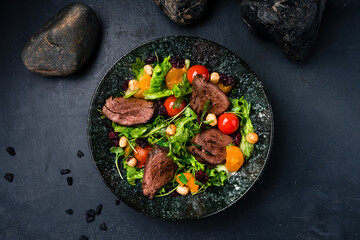 Salad beef steaks, lettuce, arugula, tomatoes, tangerines and hazelnuts.