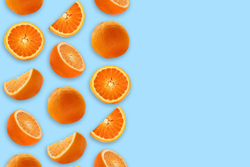 Composition of whole and sliced ​​oranges on a blue background. Food levitation.
