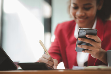 Close up american woman holding smartphone, she is using smartphone browsing social media and chatting with friends on online messaging app. The concept of using a smartphone.