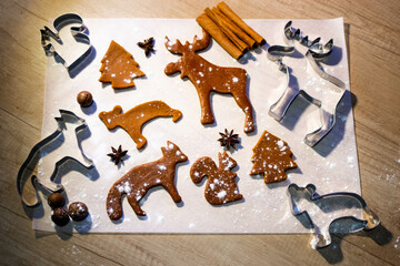 Ginger cookies and Christmas spices lie on the wooden table. The concept of the New Year and Christmas. Holiday atmosphere. Fir tree with fairy lights