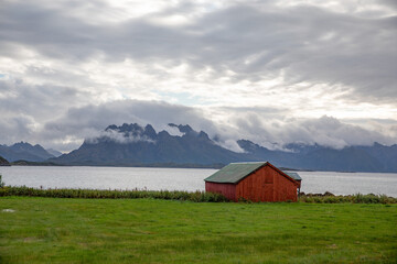Fototapeta na wymiar Red seahouse and mountains in Hadselfjord,Vesterålen,Northern Norway,Europe