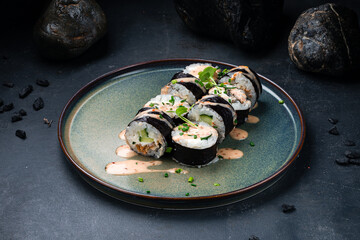 Sushi rolls set with eel, Philadelphia cheese, cucumber, rice, microgreens and chili nut sauce.