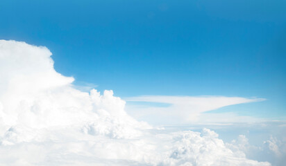 Panoramic view of blue sky and сumulus clouds through an airplane window. Flight above white cloud and horizon.