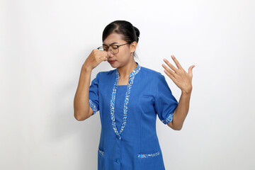 Young asian woman standing while covering her nose. Bad smell concept