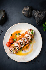 Chicken rolls in bacon with pesto sauce and sun-dried tomatoes.