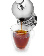 Pouring hot tea from tea kettle to glass cup. Isolated on white.