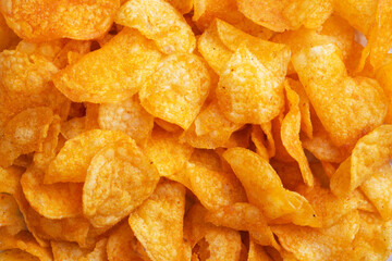 Crispy potato chips, background texture of golden chips. Fast food snack Close up
