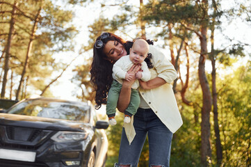 Beautiful mother with her little son is outdoors in the forest