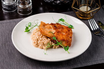 Risotto with fried white fish served with green peas.