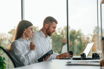 Side view. Man and woman are working in the modern office together