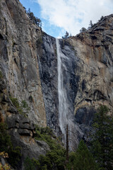 Fototapeta na wymiar Waterfall from the high gray rocks in Yosemeti national park, California, USA