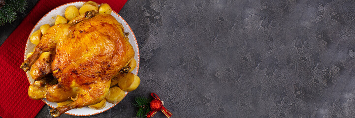 Roasted chicken and potato with Christmas decoration. Traditional food for Christmas or Thanksgiving day © aeril
