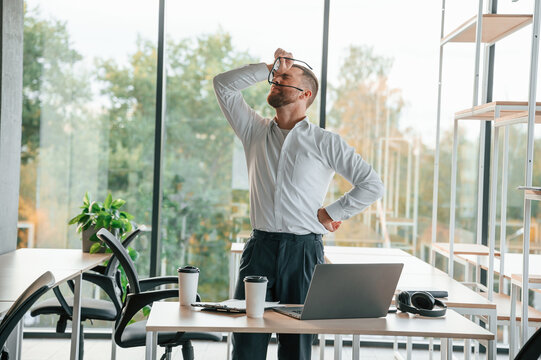 Angry, Feeling Tired And Bad. Man In Formal Clothes Is Working In The Modern Office