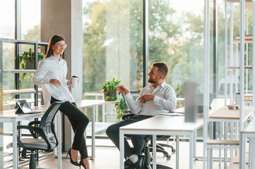 Obraz premium Friendly talking. Man and woman are working in the modern office together