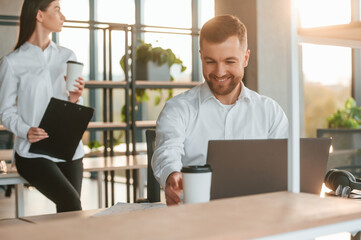 Beautiful sunlight. Man and woman are working in the modern office together