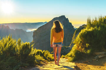 Sporty woman walking barefoot in the evening sun on Pico do Ariero on a super beautiful hiking...