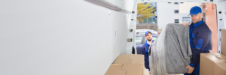 Two Movers Unloading Furniture From Truck