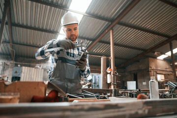 Fototapeta na wymiar Measuring the object. Factory male worker in uniform is indoors