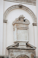 Obraz premium An architectural element in the form of a closed arch, a portal with seraphim and flat bas-relief columns on the corner of a Jesuit church in Lviv, Ukraine. ?opy space.