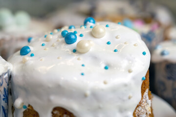 Homemade easter cakes with white topping, confectionery decoration, frozen white icing sprinkled with blue and white round confetti