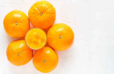 Fresh orange juice in the glass with orange fruit on wood background