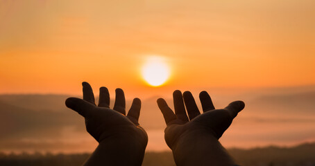 Faith of christian concept: Spiritual prayer hands over sunshine with blurred beautiful sunrise or...